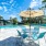 Large sparkling blue pool with a large pool deck and lounge chairs