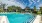 Large sparkling blue pool with a large pool deck and lounge chairs