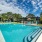 Large sparkling blue pool with a large pool deck and lounge chairs