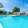 Large sparkling blue pool with a large pool deck and lounge chairs